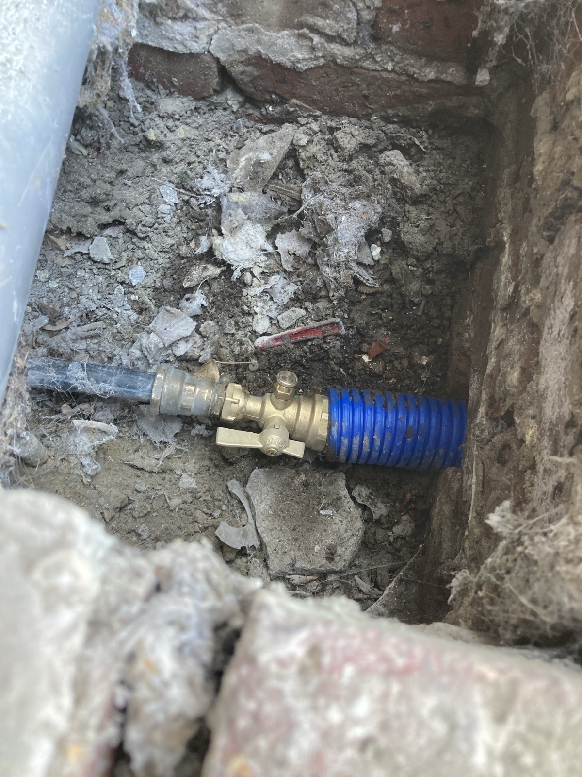 Robinet d'arrêt raccordé sous gaine TPC bleue, près du compteur d'eau